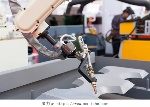 工业机器手臂的特写工业焊接机器人手臂中焦，在背景中的模糊焊机